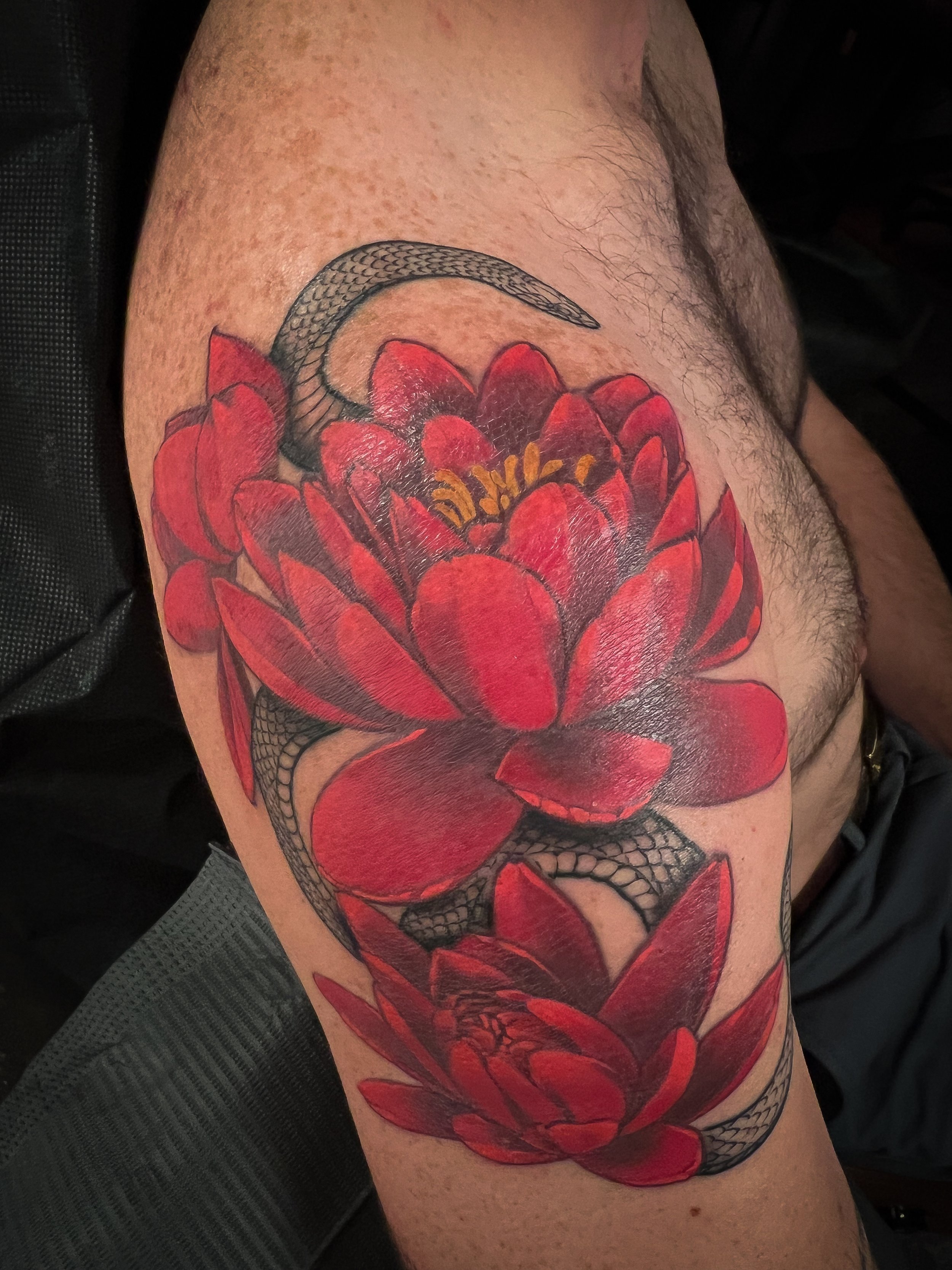 vibrant red peonies and fineline blackwork snake winding through