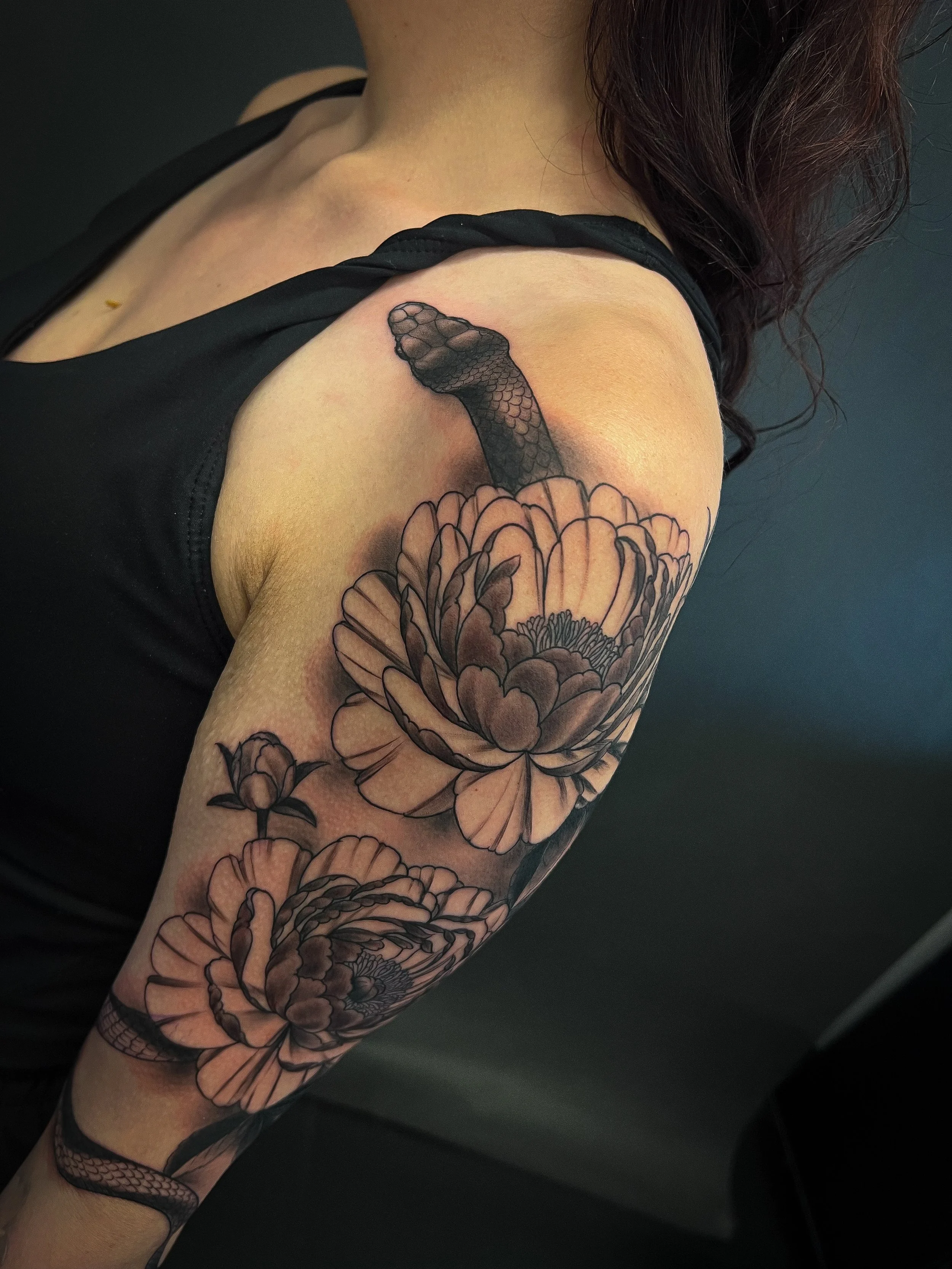 black and grey blackwork snake and peonies tattoo