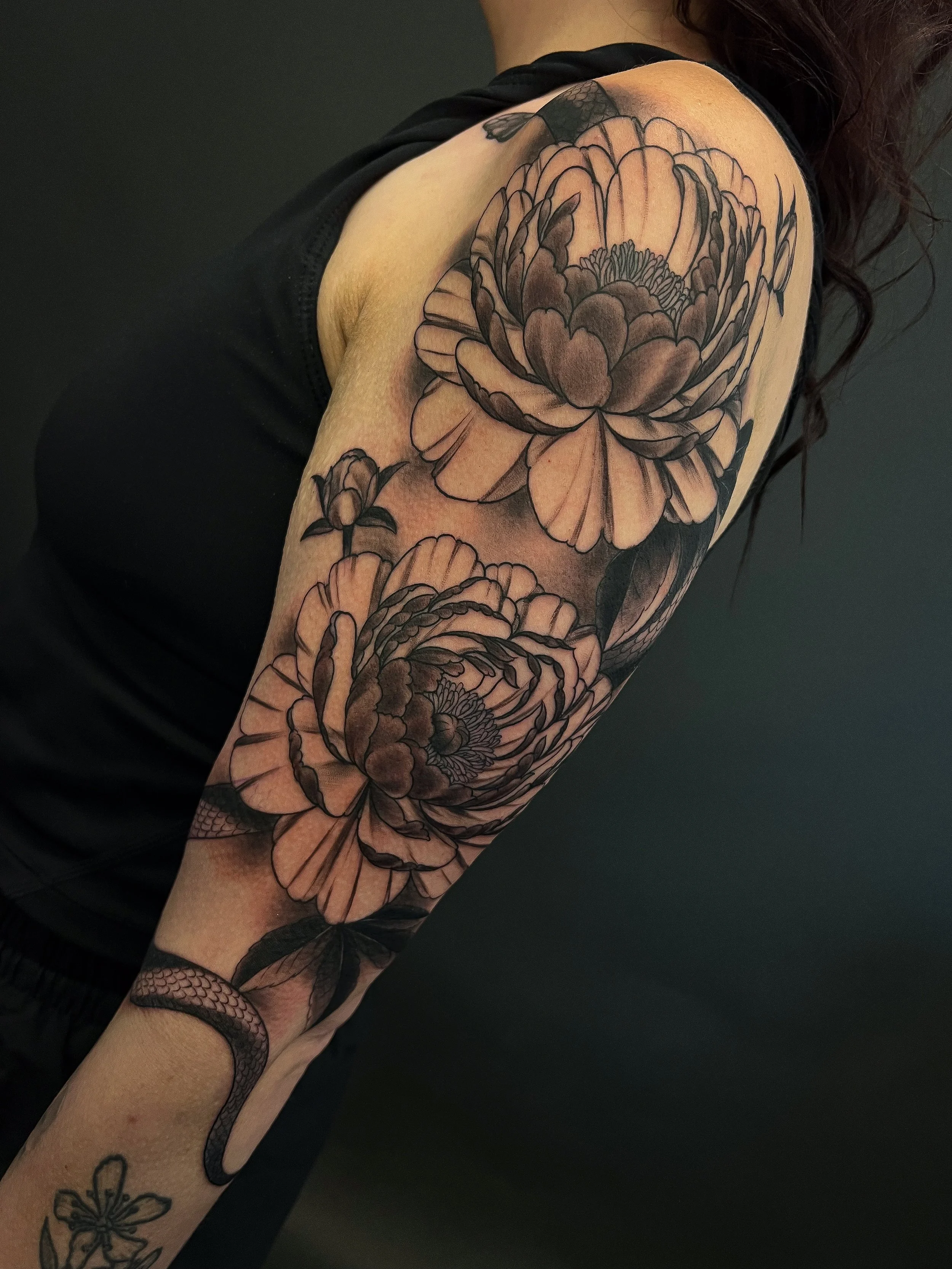 black and grey blackwork snake and peonies tattoo