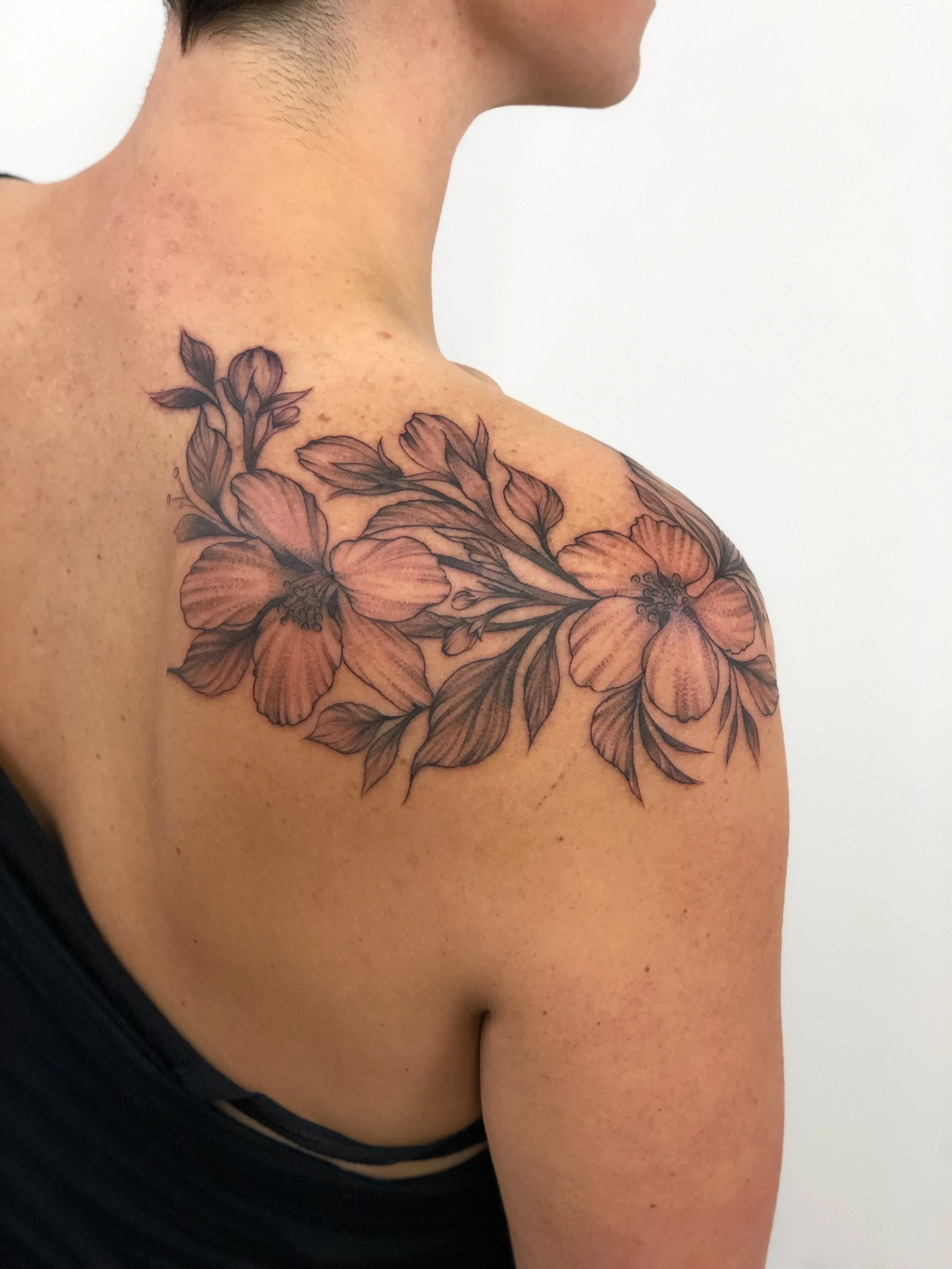 Fineline Blackwork Floral Tattoo with leaves on shoulder