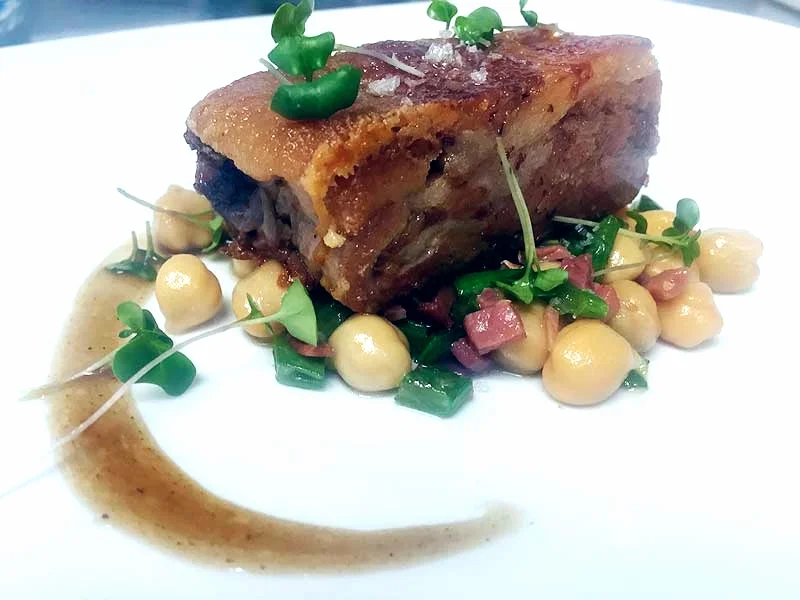 Codillo de cerdo con trinchat de garbanzos y judía verde