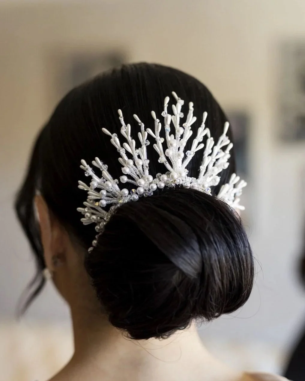 Bride wearing her mom's vintage crown repurpose to a statement style back piece above her bridal bun hairstyle.