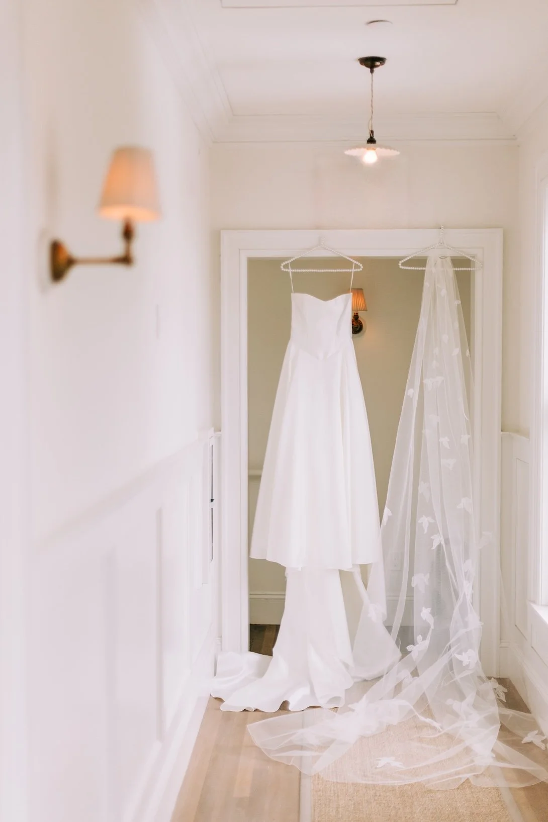 Flora wedding gown and mom's repurposed bridal veil hanging from doorway.