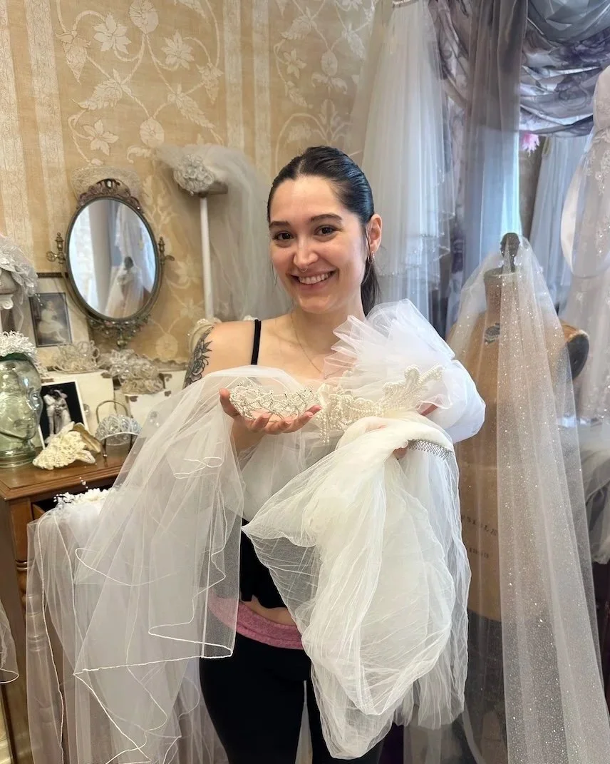 Bride to be holding her family heirloom headpieces while at Headpiece.com.