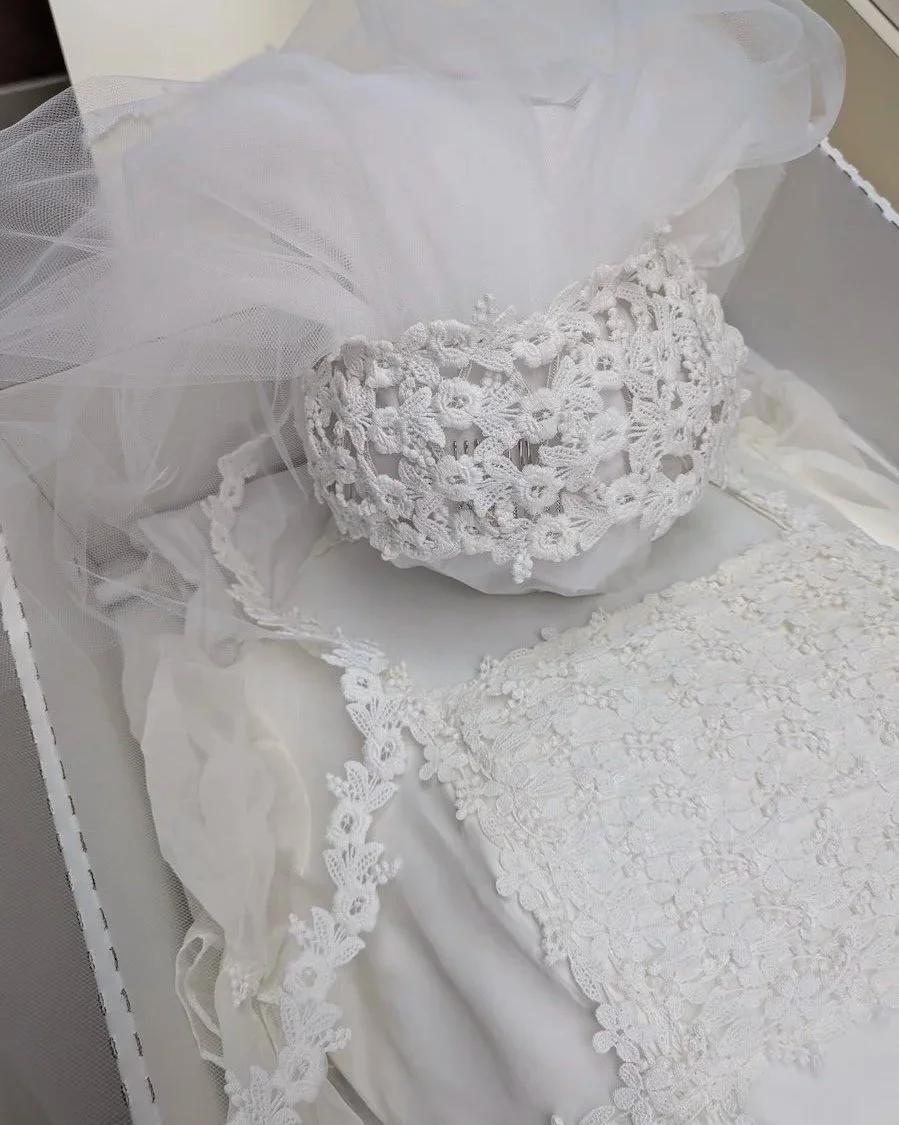 Lace Juliet cap expertly restored laying over preserved 1970s wedding gown.