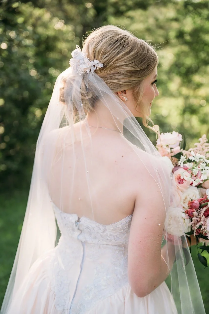 Bride wearing her mom's 90s respurposed bridal headpiece with new wedding veil in a blush color palette.