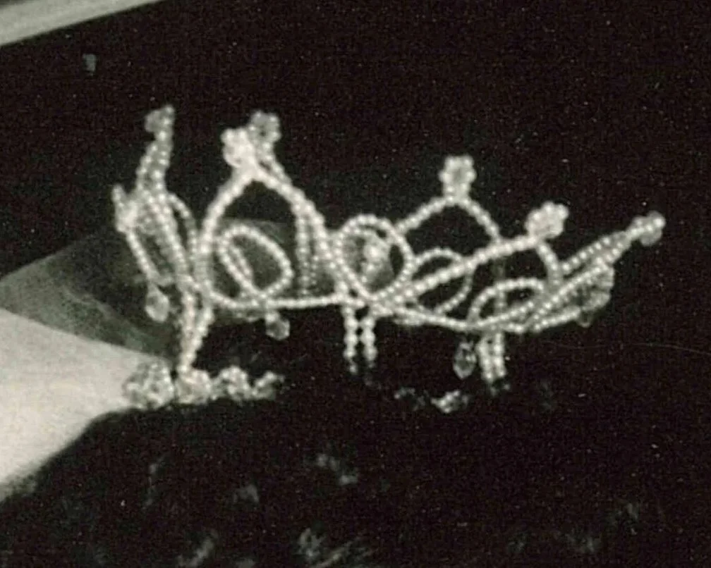 Close up photo of vintage 1960 pearl and crystal wedding crown on brides head.