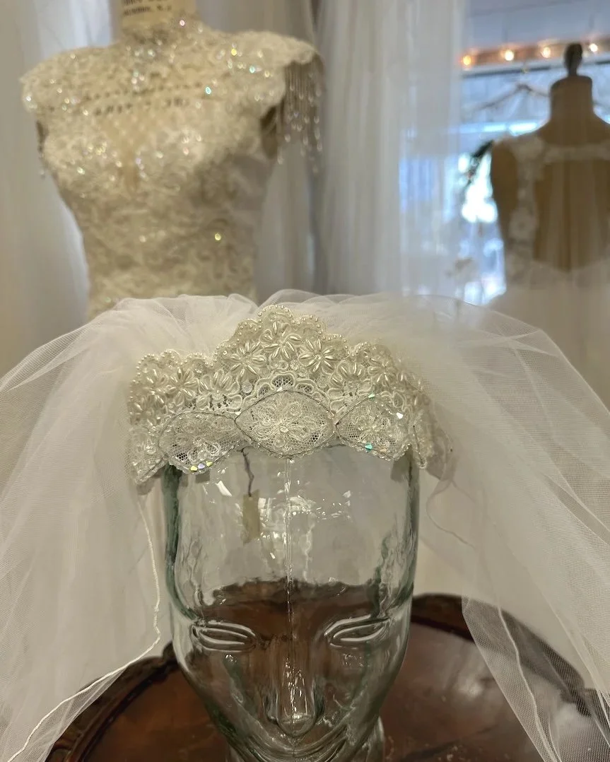 1987 lace crystal headpiece and veil on glass head in bridal salon
