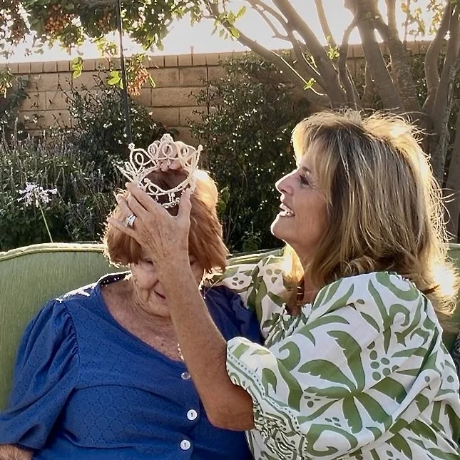 Daughter placing recreated vintage wedding crown on mom's head.