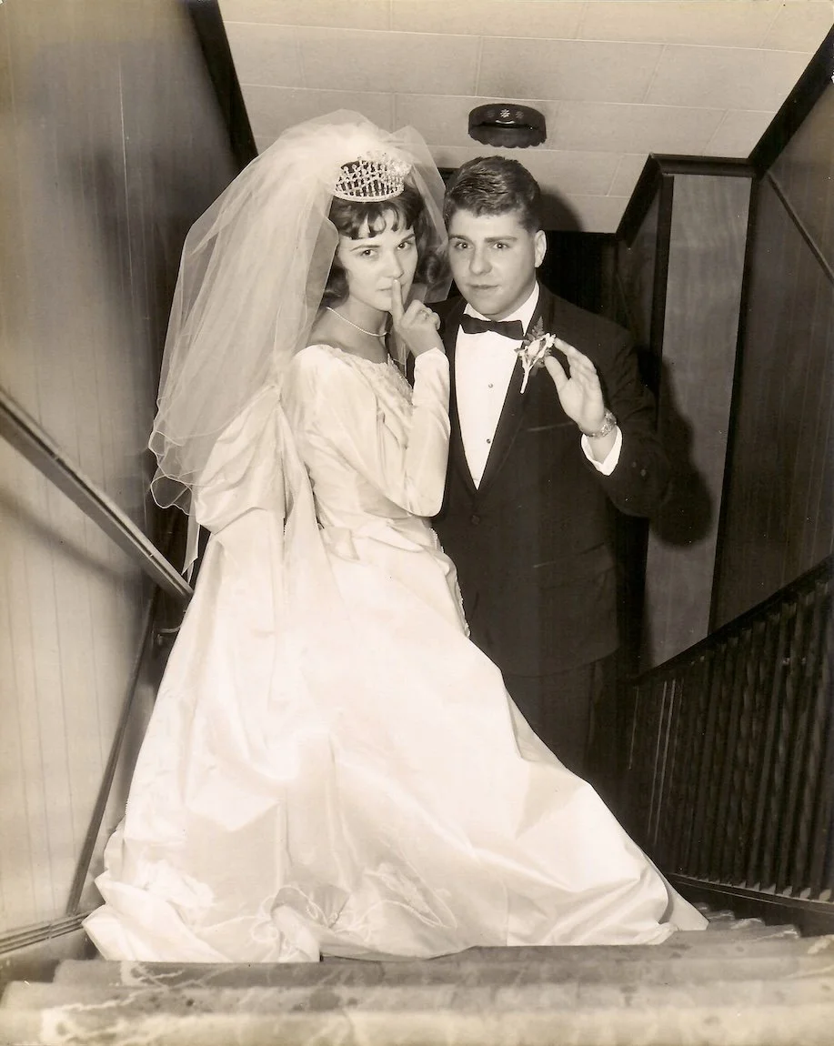 Black and white wedding portrait of bride and groom wearing a crystal and pearl crown and bouffant wedding veil.