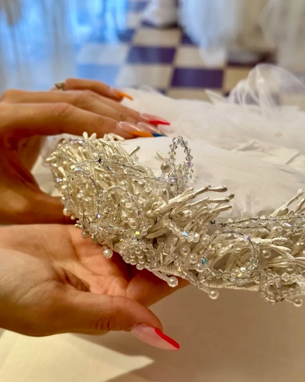 Bride holding her mom's 1992 vintage headpiece with hopes to restore tarnished wire, dirty crystal, and oxidized glue.