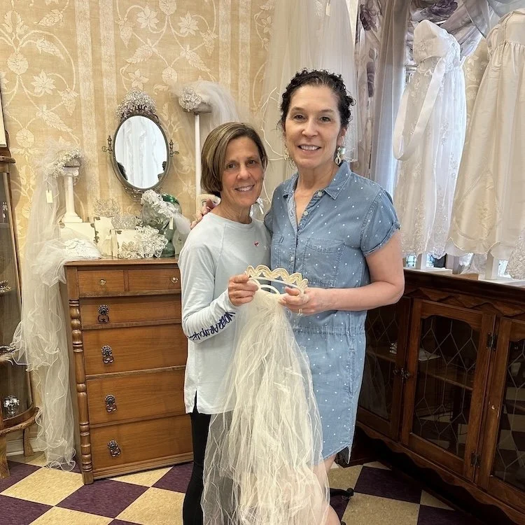 Marie and Karen holding her mom's vintage headpiece for donation.