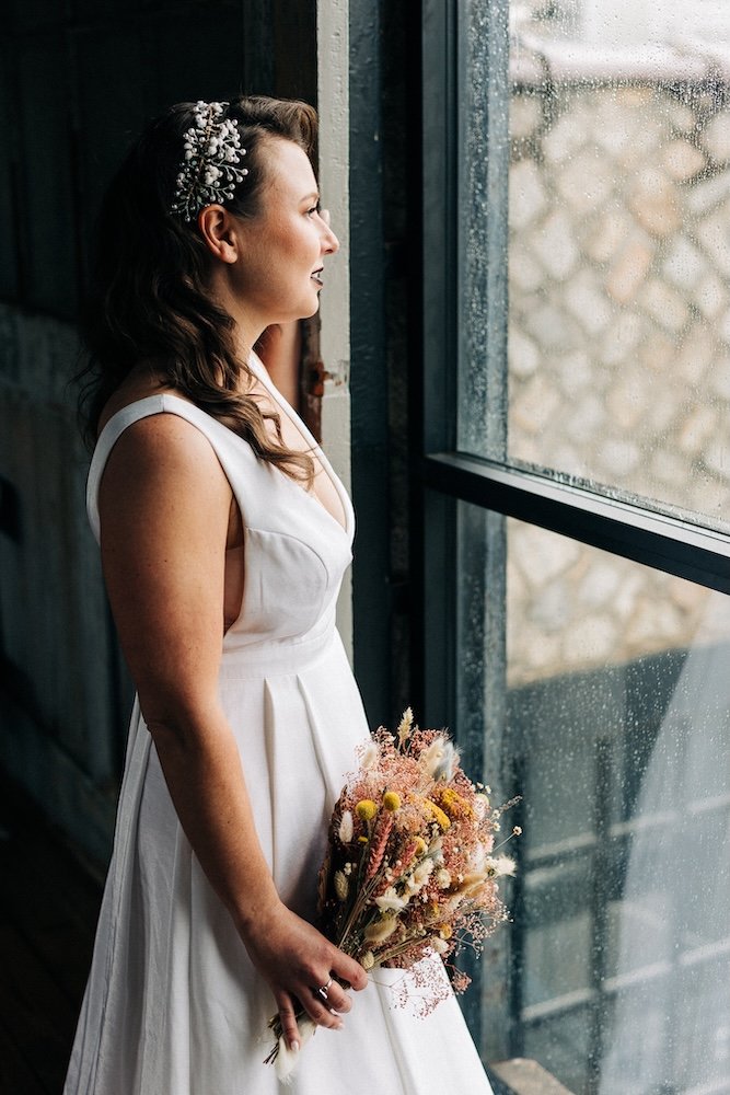 Virginia bride looking out a rainy window wearing her mom's headpiece restyled into a statment pearl piece.