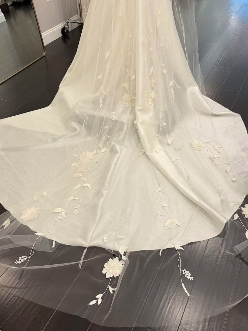 Floral leaf detail on a wedding veil overlaying wedding dress.