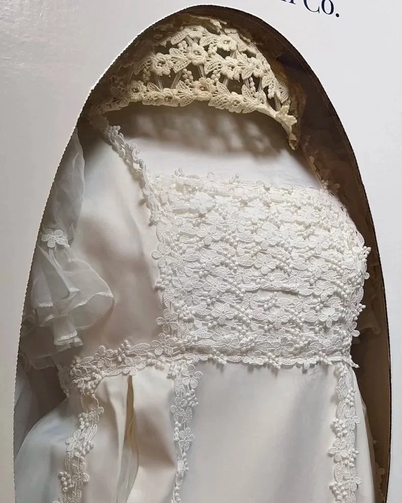 Yellowed, oxidized lace Juliet cap stored in a box with a beautifully preserved wedding gown.