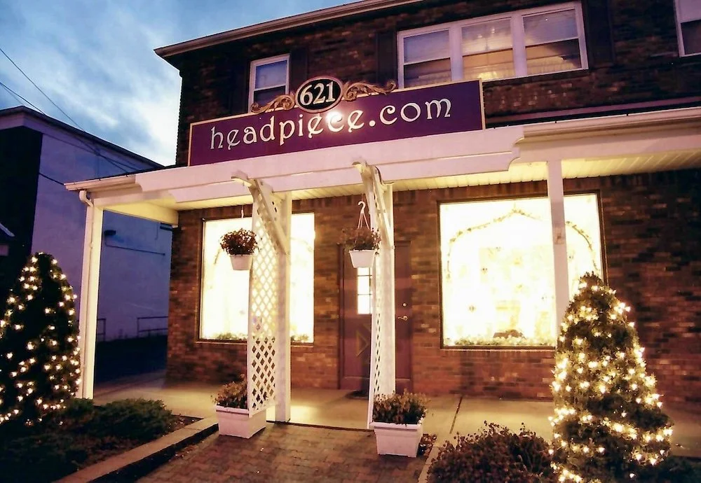 Exterior of Headpiece.com brick and mortar store at dusk.