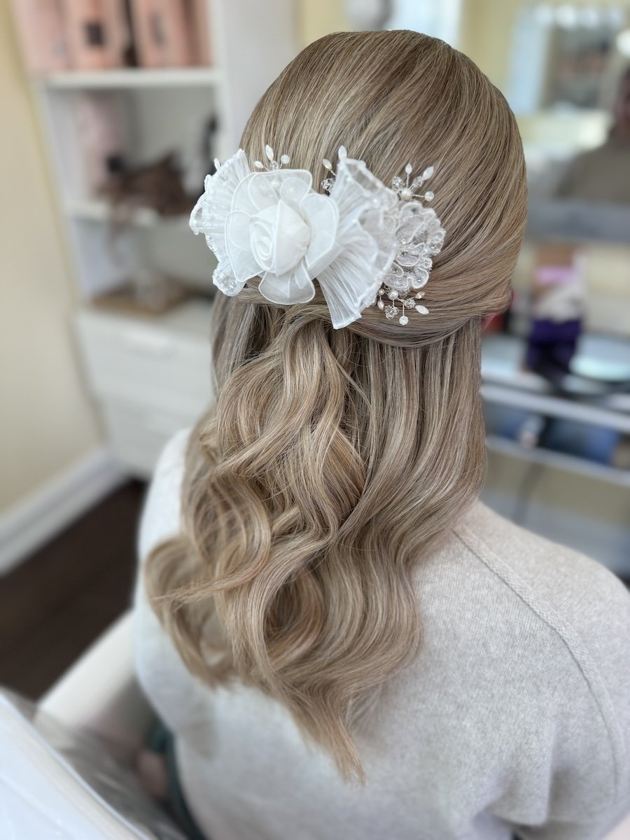 Bride at hair tiral with hair down and pulled half back wearing mom's repurposed 80s headpiece