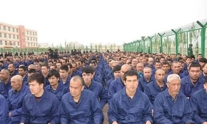 Photo reported to show detainee in a Xinjiang Re-education Camp located in Lop County listening to "de-radicalization" talks.  Photo Source: Wikipedia Xinjiang Re-education Camp Lop County