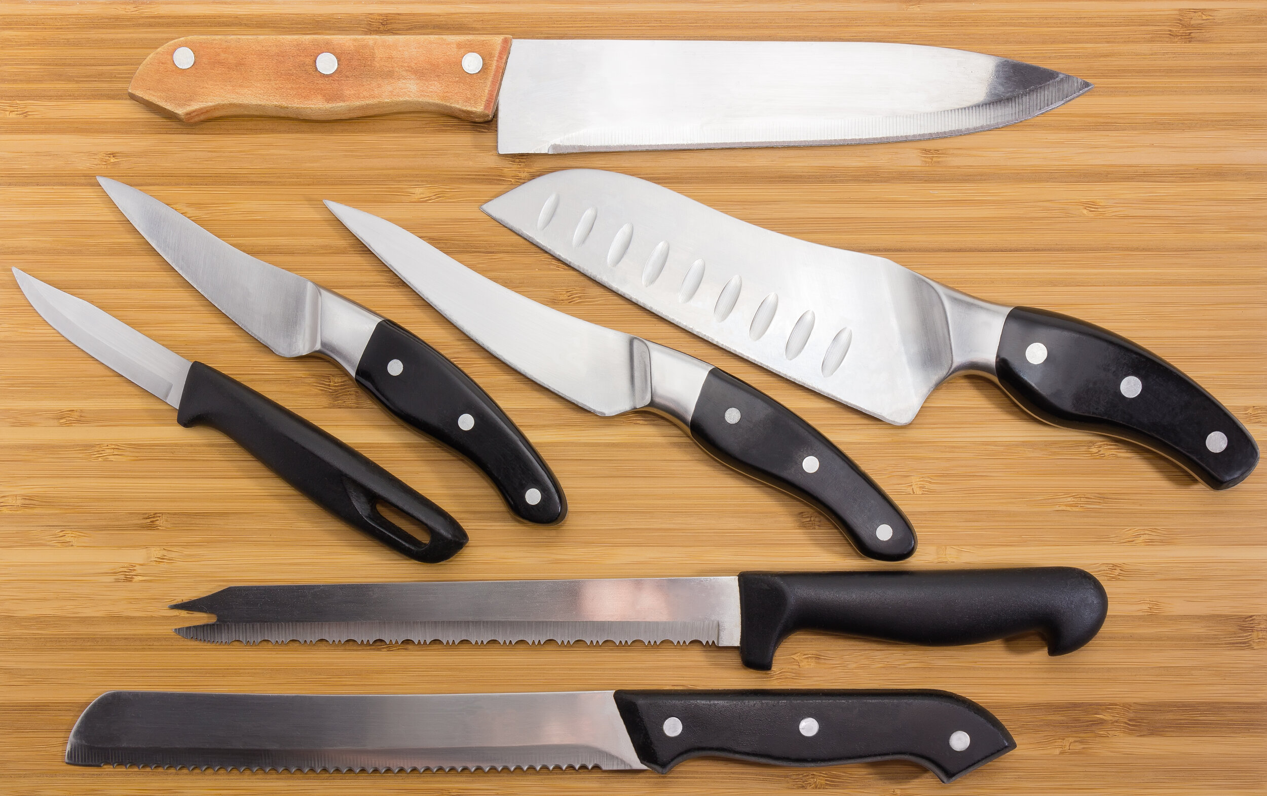 Background-of-different-kitchen-knives-on-the-bamboo-cutting-board-1136552450_5076x3192.jpeg
