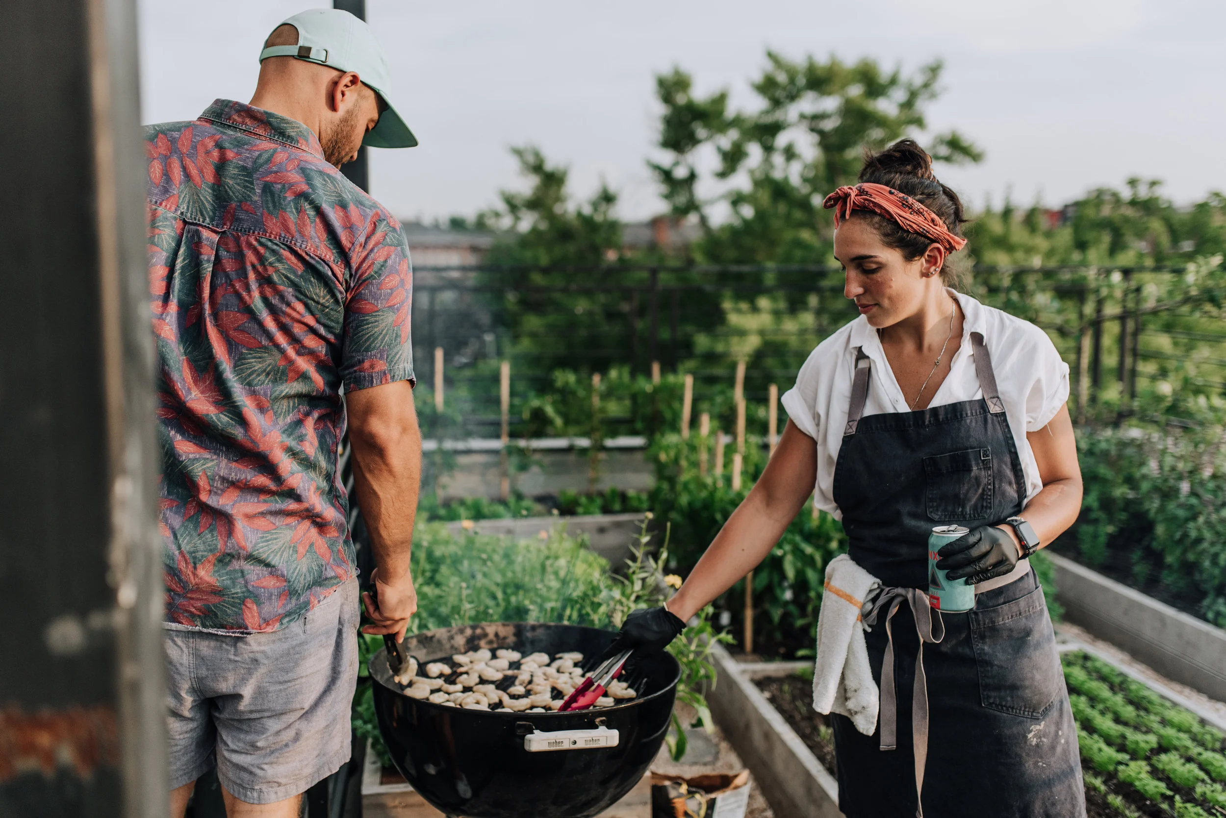 Timber Pizza Co. founder Andrew Dana and Chef Daniela Moreira preparing the meal next to the rooftop garden. 