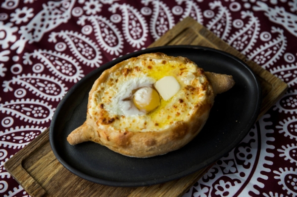 Ajaruli, the most popular style of khachapuri served at Supra, features bubbling cheeses and a fried egg.