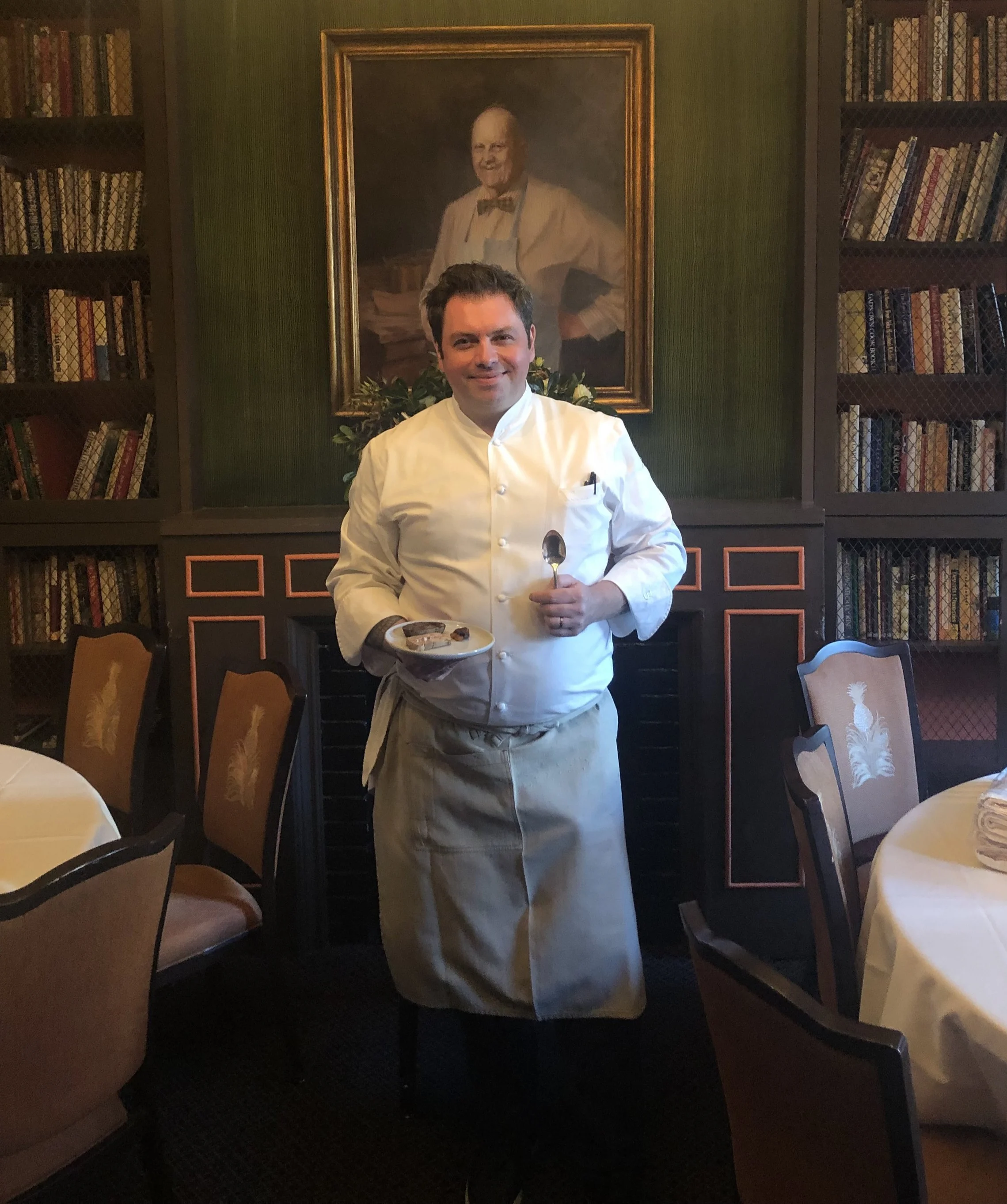 Chef Sebastien Rondier of Brabo stands in front of a portrait of James Beard at the James Beard House in NYC.