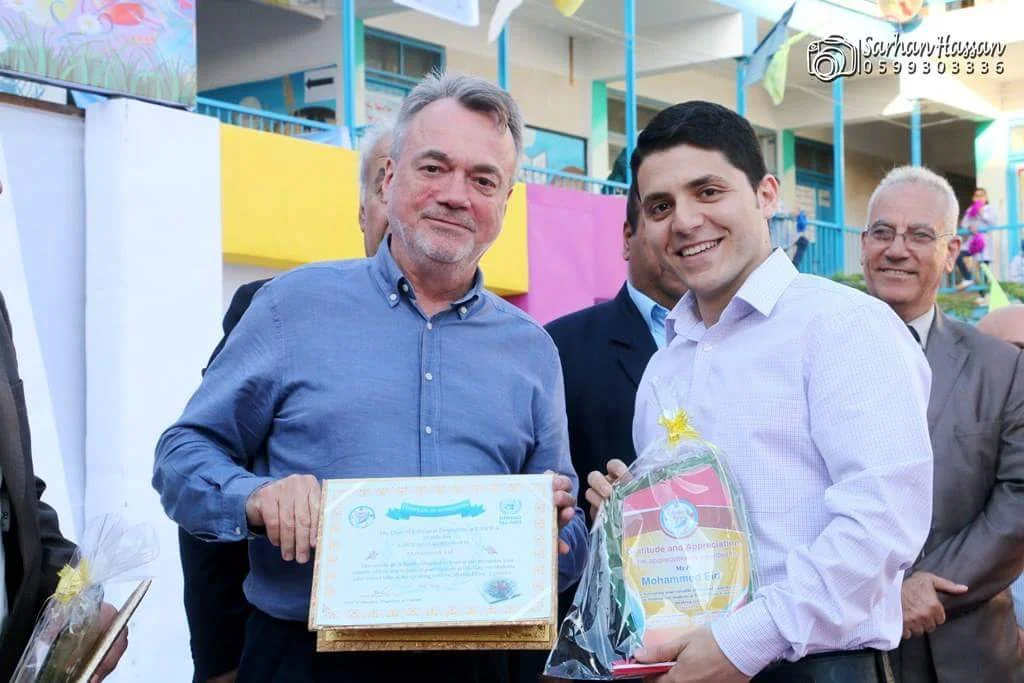 Mohammed receiving a certificate of gratitude by Bo Schack, Director of UNRWA operations in Gaza Strip, due to his contributions to the agency.