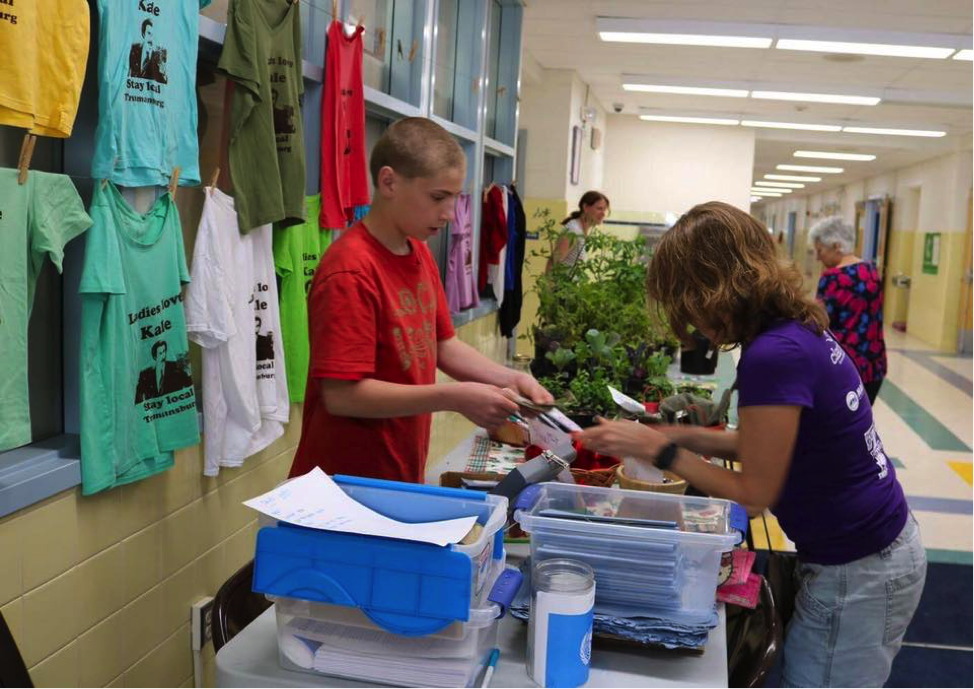 Localvore students set up a table in their school, to sell t-shirts, cookbooks and other handmade items. Photo by Laura Rowley.