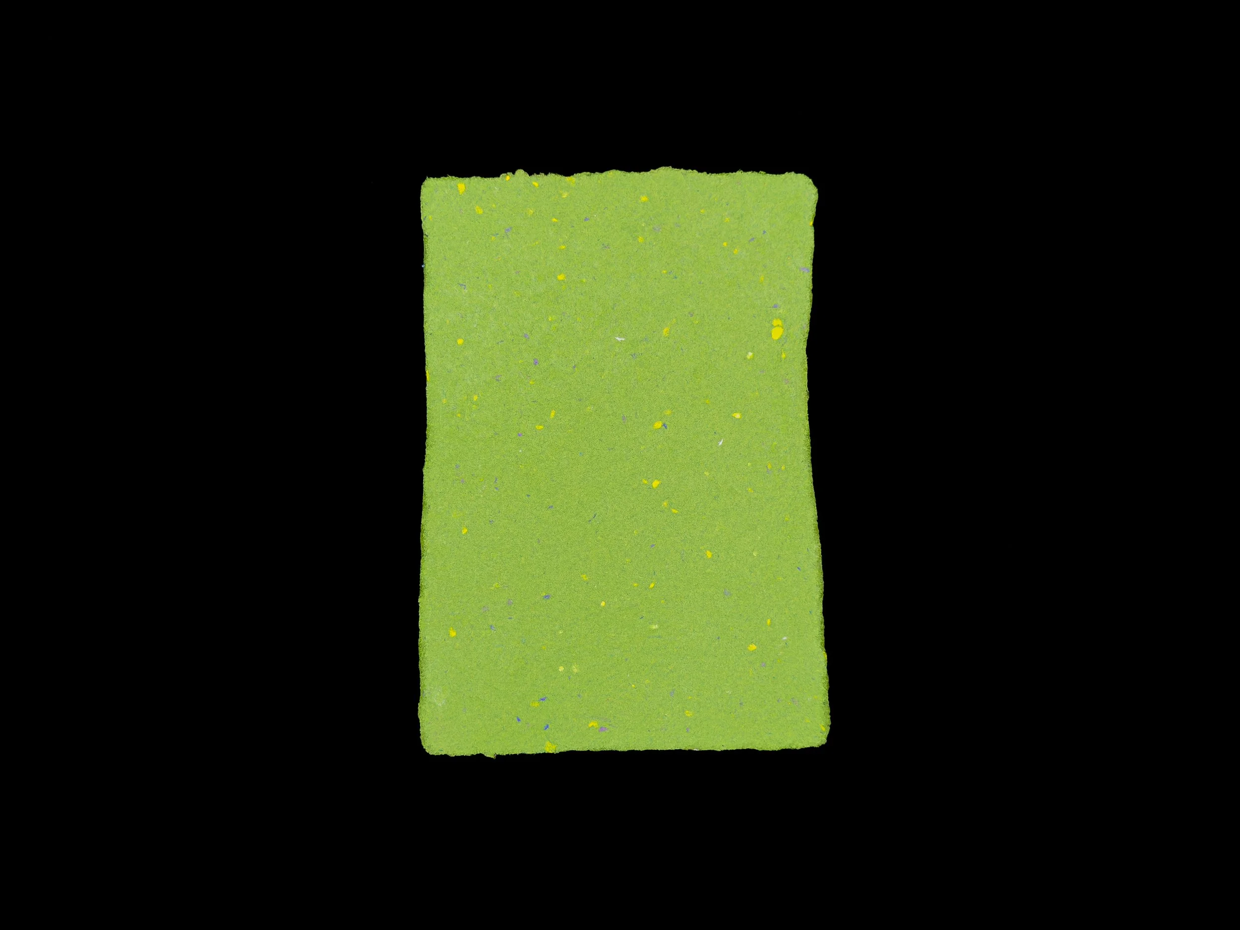 Moss green sheet of handmade paper on a black background.