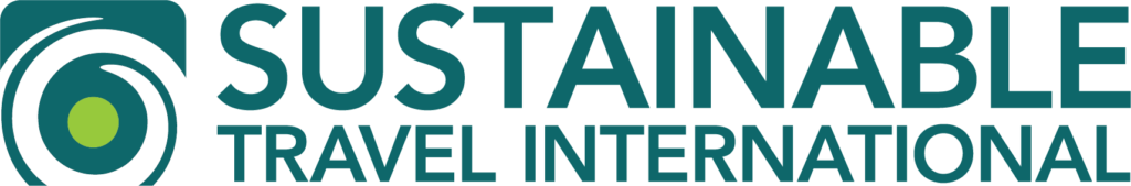 Sustainable Travel International logo featuring a circular green and white emblem and the organization name in bold black and teal text.