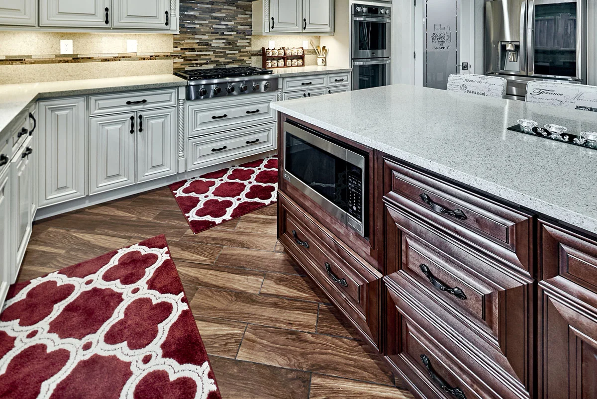 TWO TONE KITCHEN CABINETS WITH UNDER COUNTER MICROWAVE IN ISLAND.