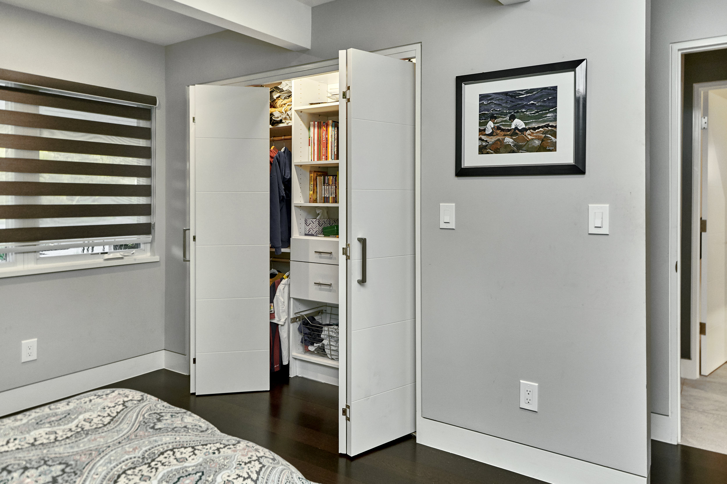 CLOSET WITH BIFOLD DOORS FOR BETTER ACCESS.