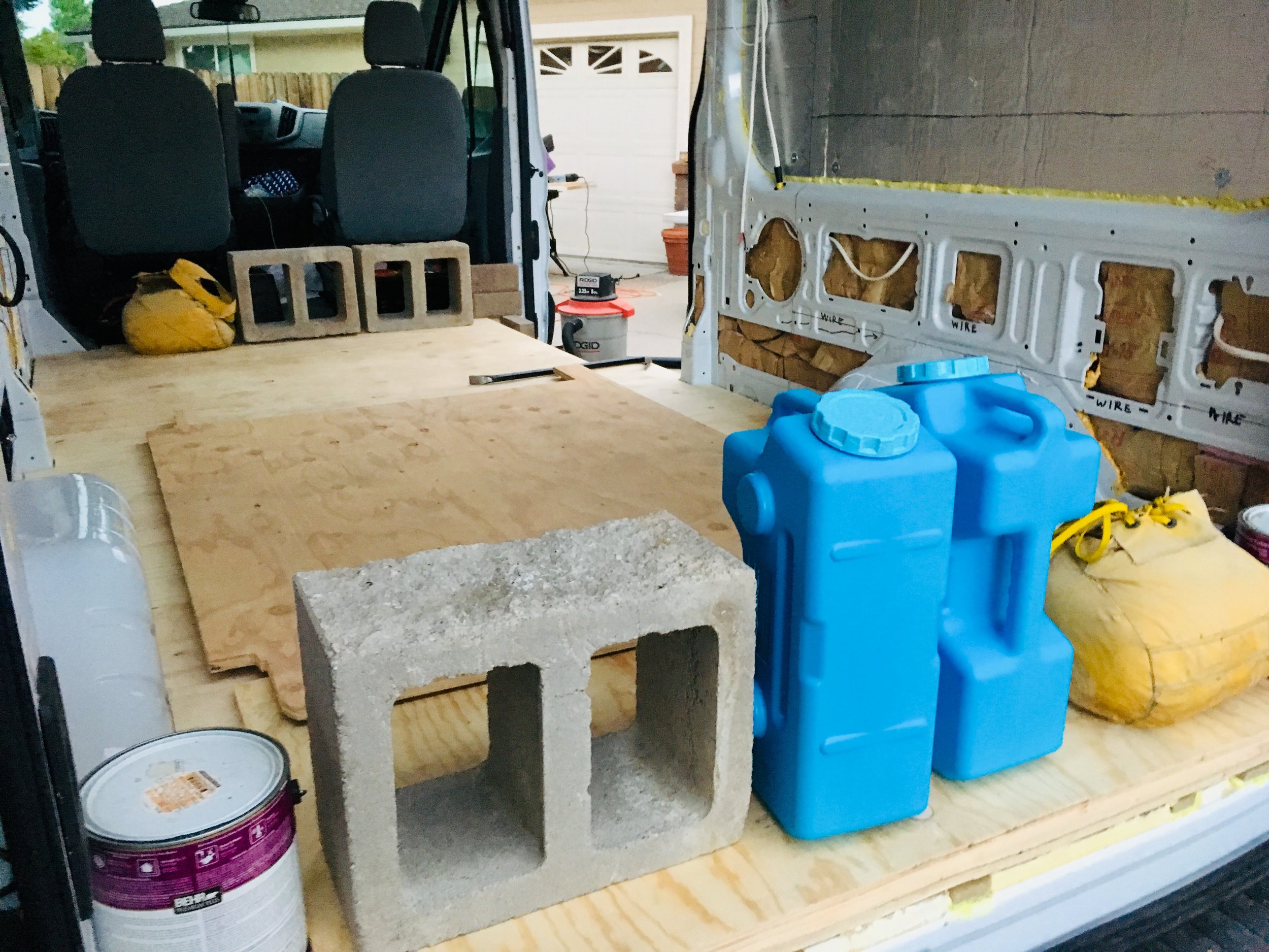 We weighed down the subfloor with everything we could find…. including a couple of the water jugs that we’re going to use for my sink system.