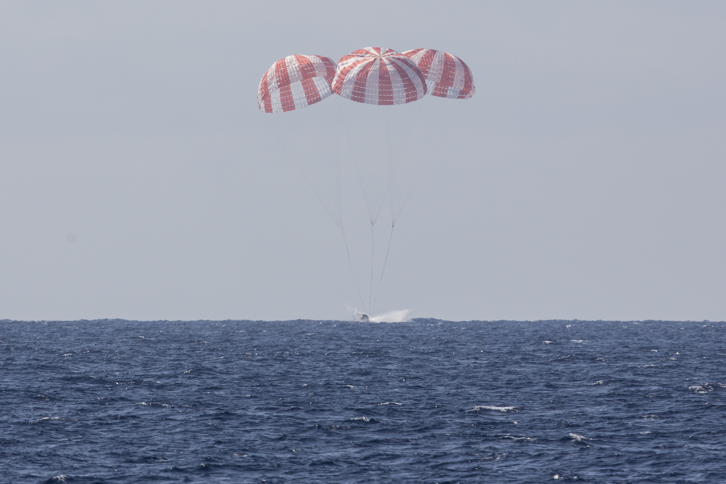  Dragon parachutes into the Pacific Ocean after leaving the ISS. Photo Credit: SpaceX 