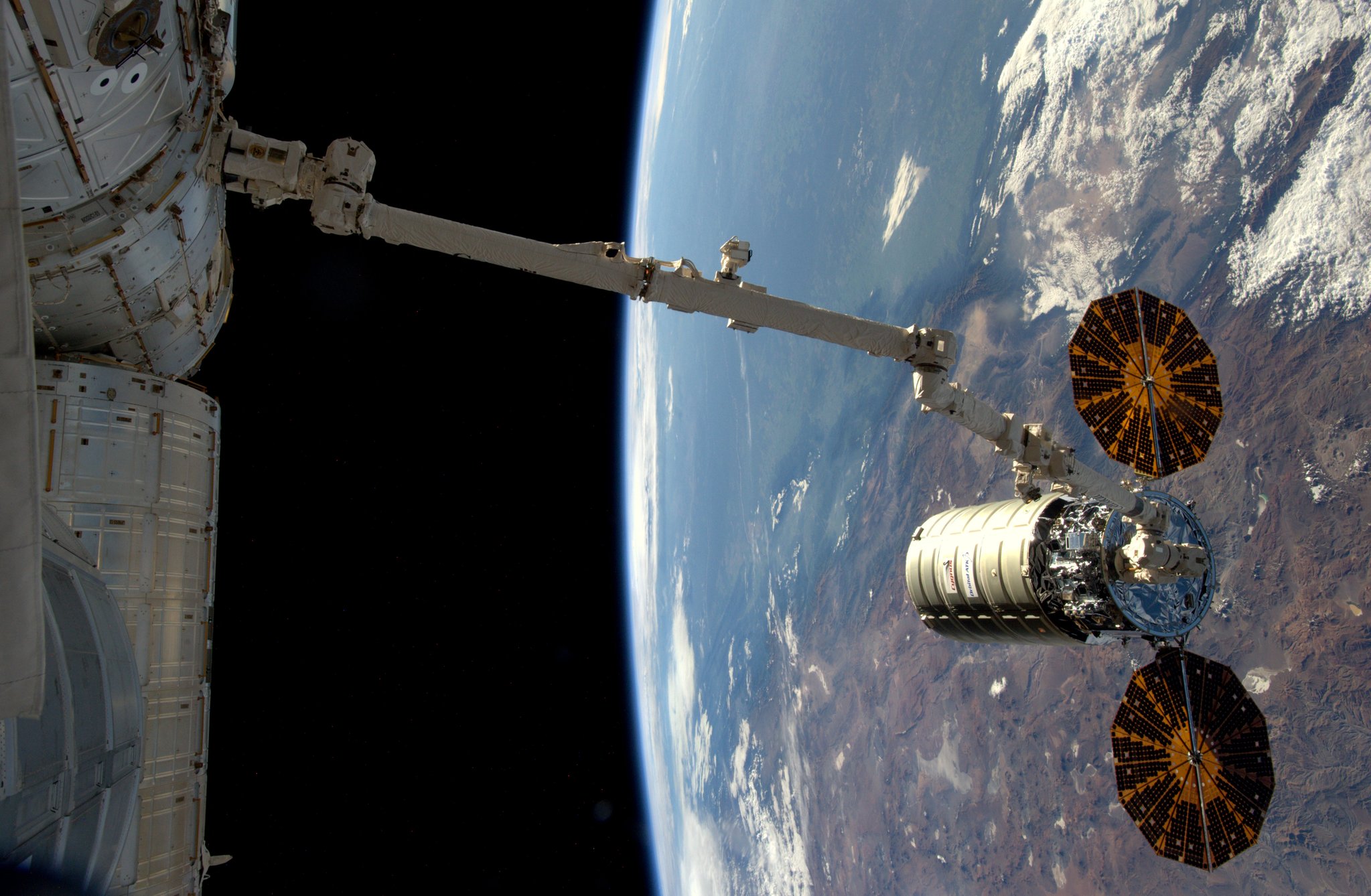  The robotic arm begins to pull Cygnus toward the ISS to berth the vehicle. Photo Credit: NASA 