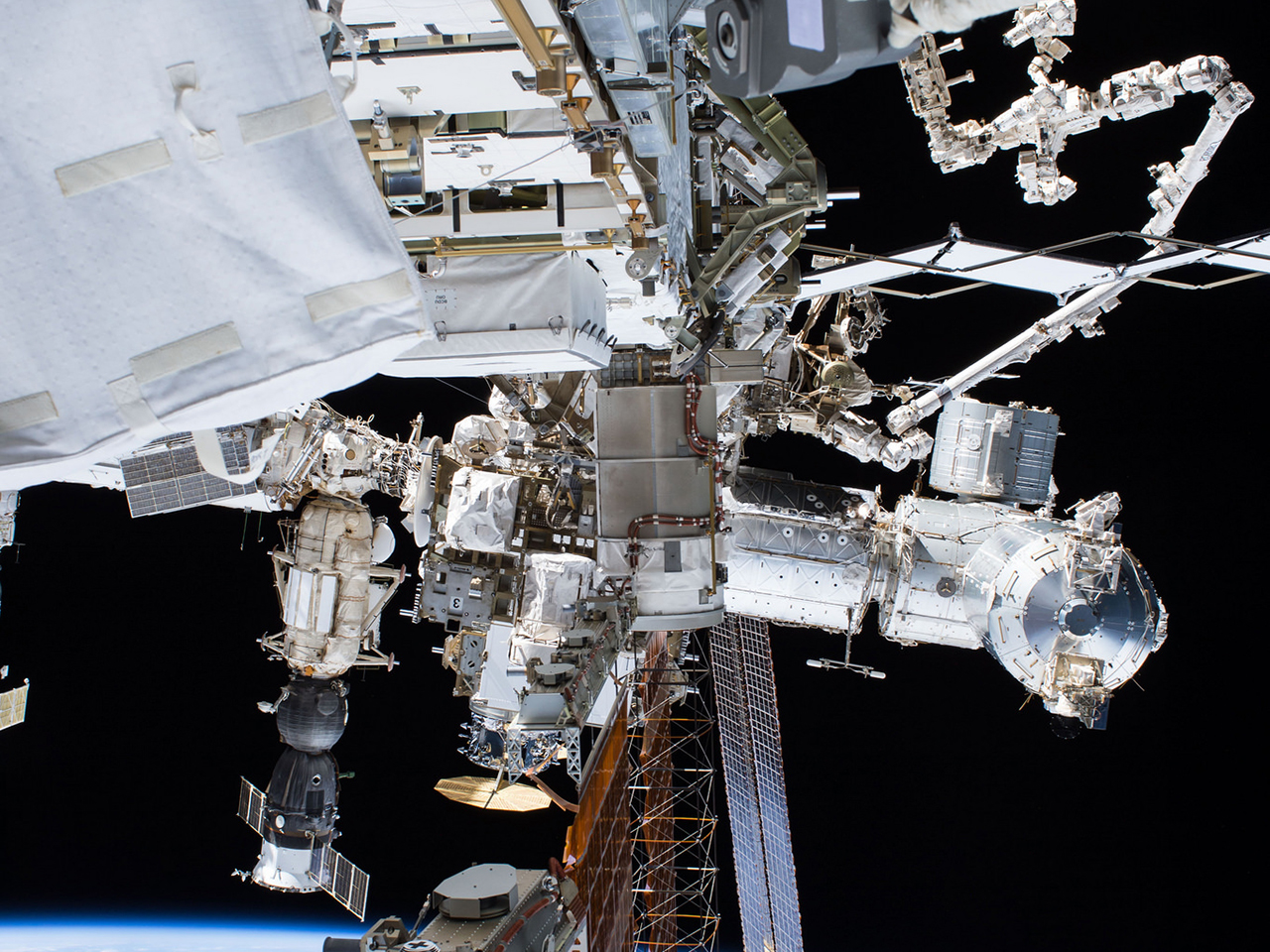 A spacewalking astronaut's view of the outpost. Cygnus can be seen near the center. Photo Credit: NASA