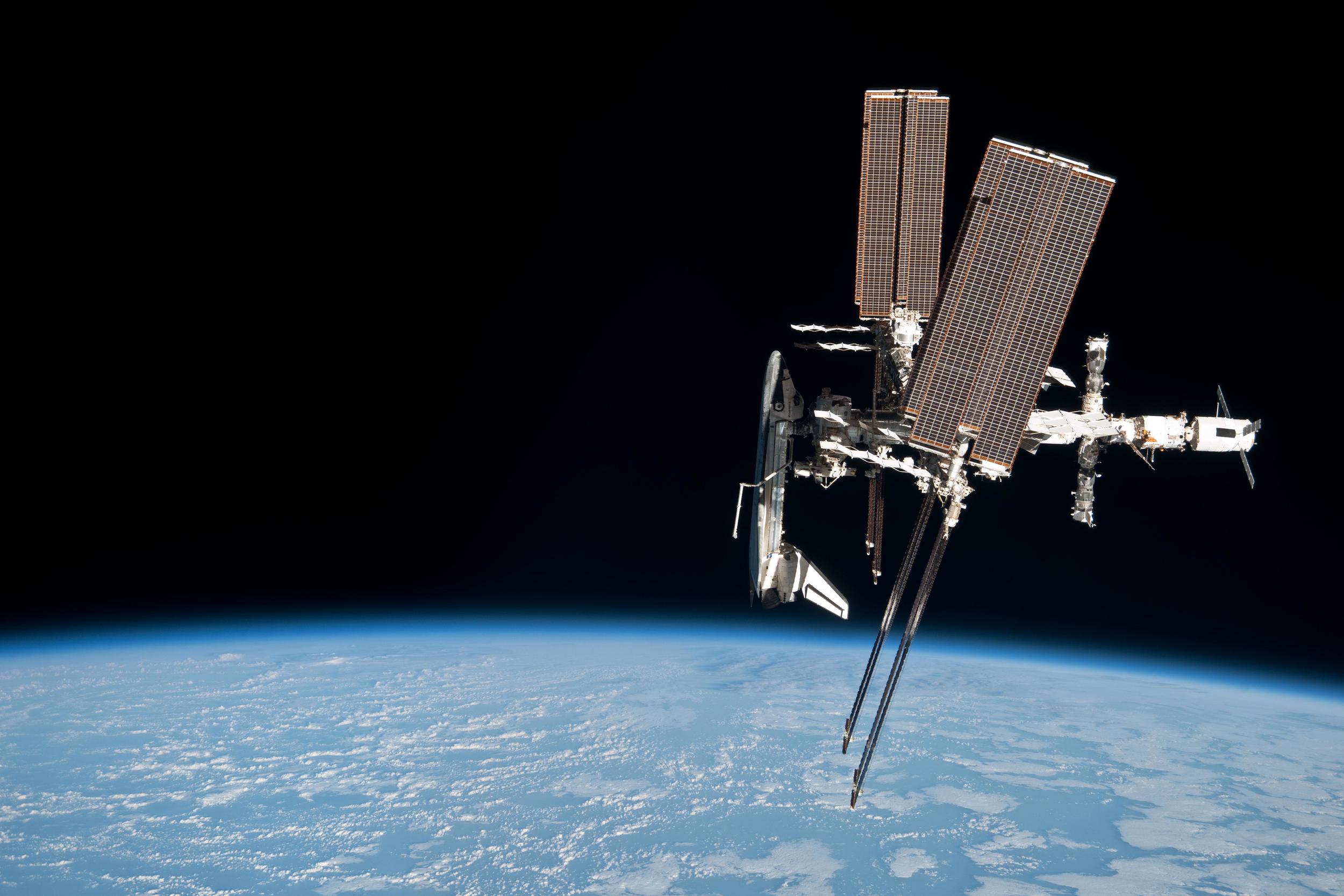  The space shuttle  Endeavour  is seen docked with the ISS by a departing Soyuz crew. Photo Credit: NASA 