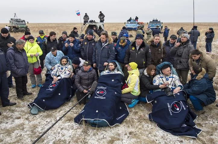 Russian cosmonauts Mikhail Kornienko, left, Sergey Volkov of Roscosmos center, and Expedition 46 Commander Scott Kelly of NASA rest in chairs outside of the Soyuz TMA-18M spacecraft after they landed. Photo Credit: Bill Ingalls / NASA