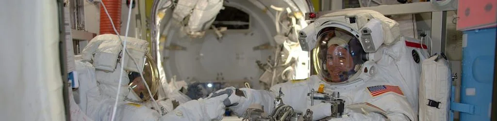 Shane Kimbrough, right, and Peggy Whitson shake hands before venturing into the Quest airlock to begin a 6.5-hour spacewalk to help upgrade the International Space Station's power system. Photo Credit: Thomas Pesquet / NASA