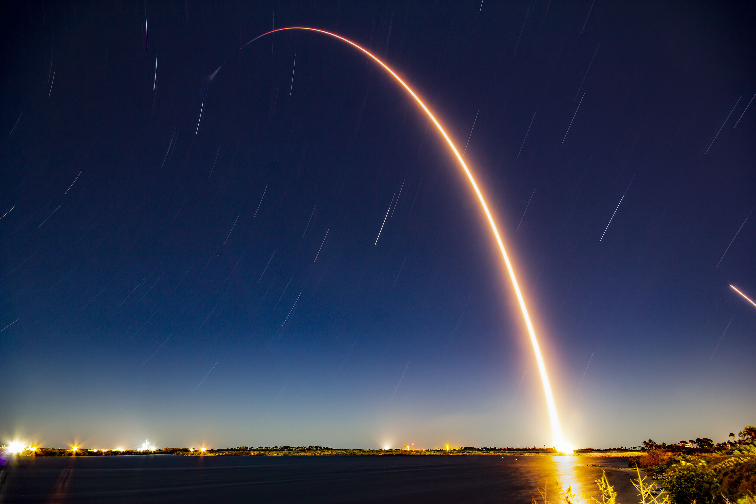  A long exposure of Falcon 9 streaking toward Space with the CRS-20 Dragon spacecraft. The first stage’s landing burn can also be seen on the far right of the image. Credit: SpaceX 