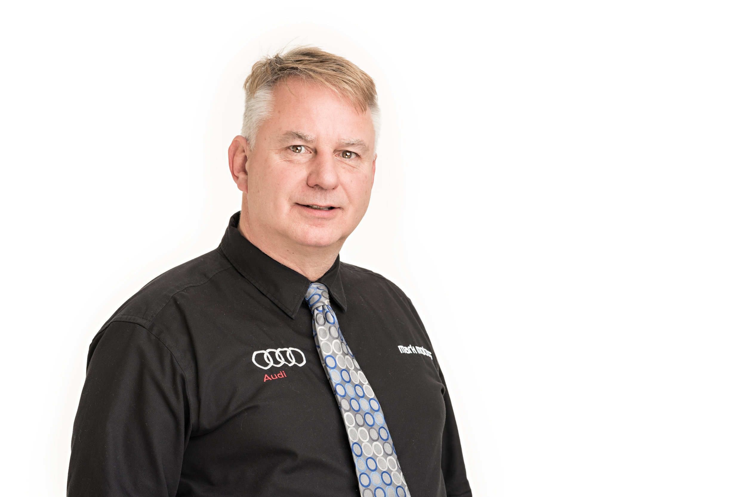 A professional headshot of a man on a white background