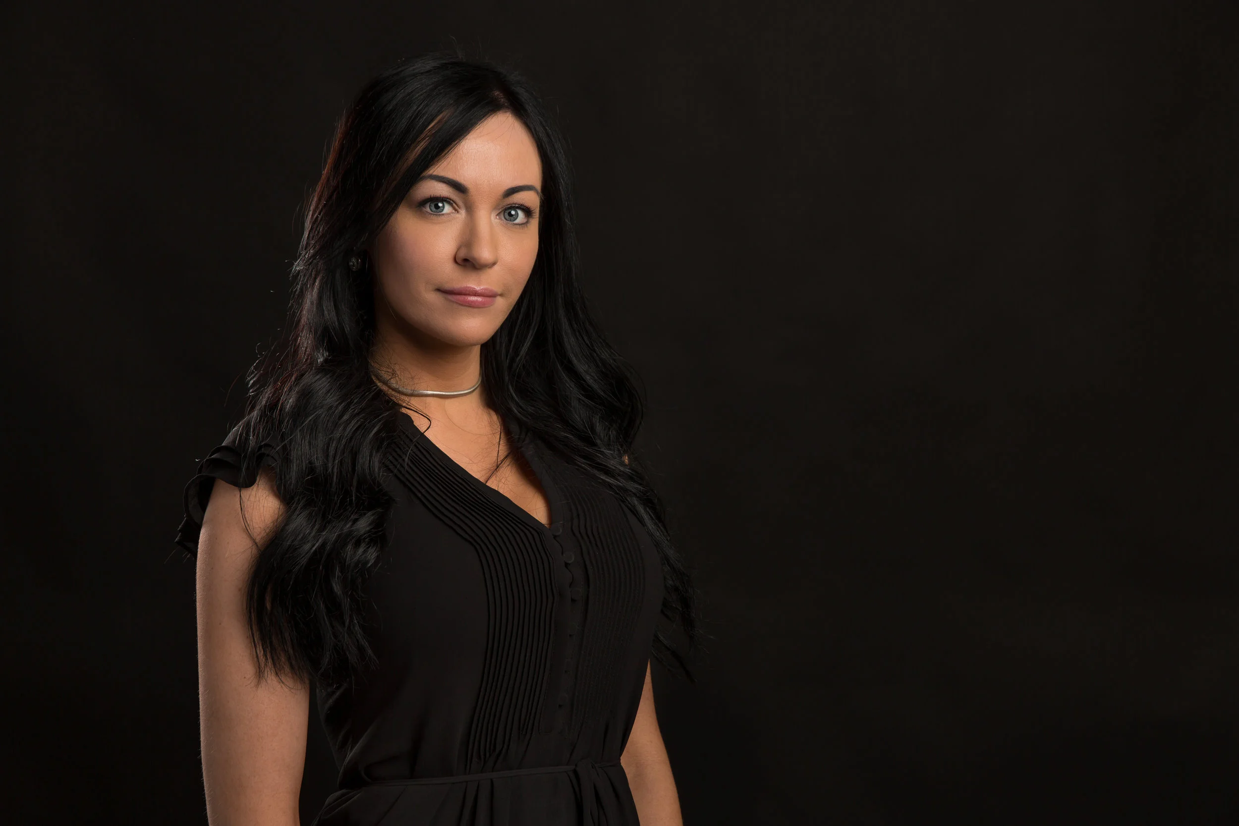 Headshot on a black backdrop of a female professional