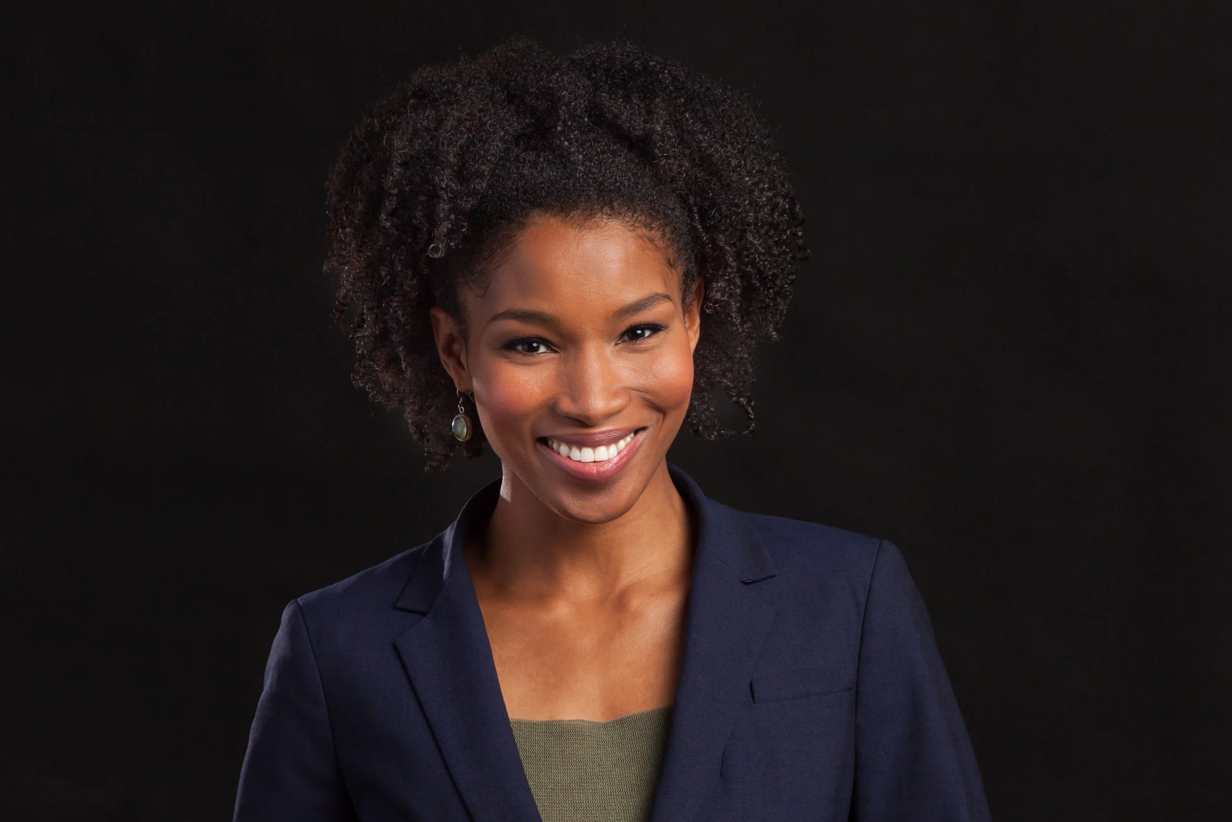 Headshot on a black backdrop of a female professional