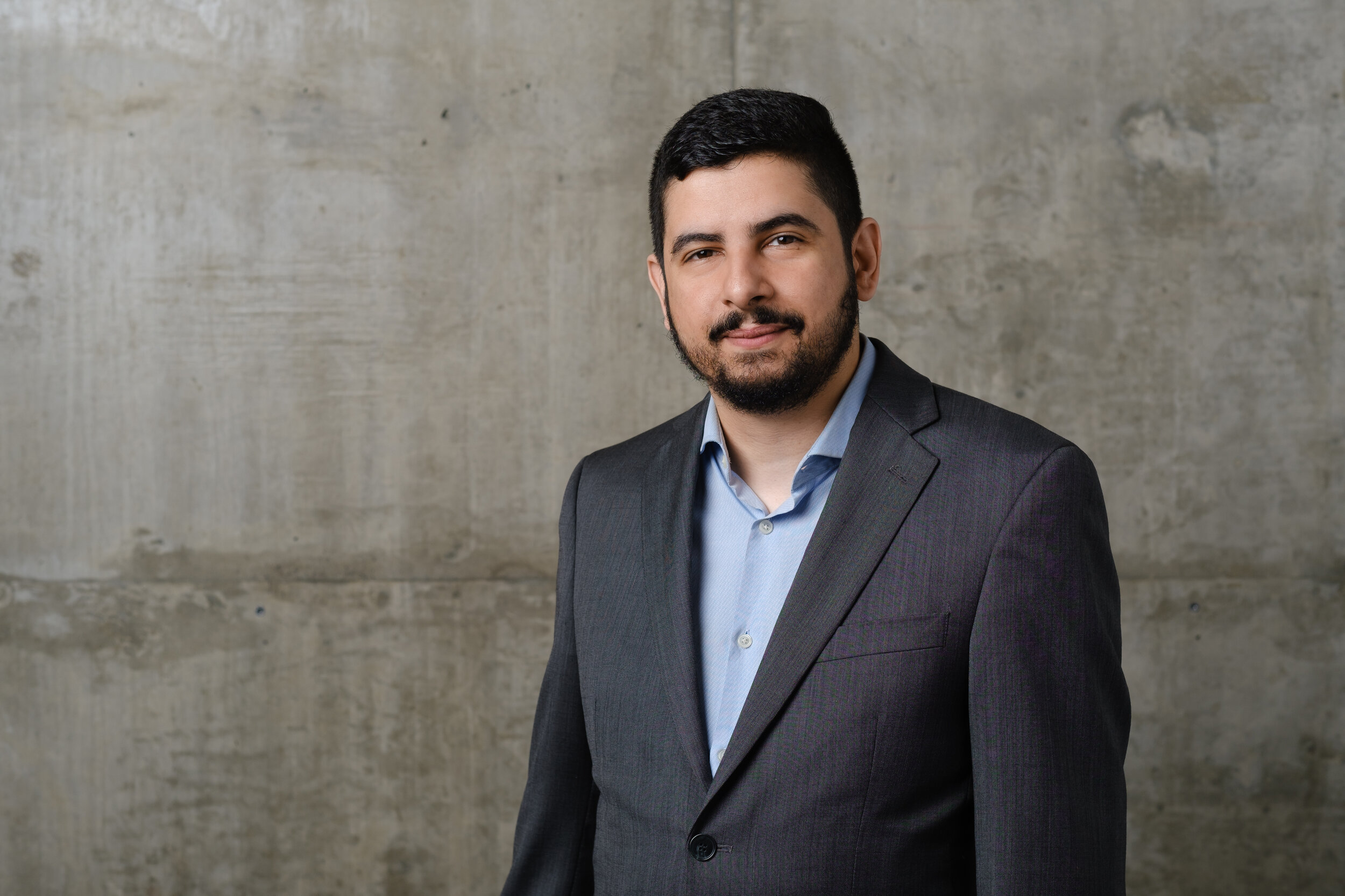 headshot of a man on a concrete backdrop