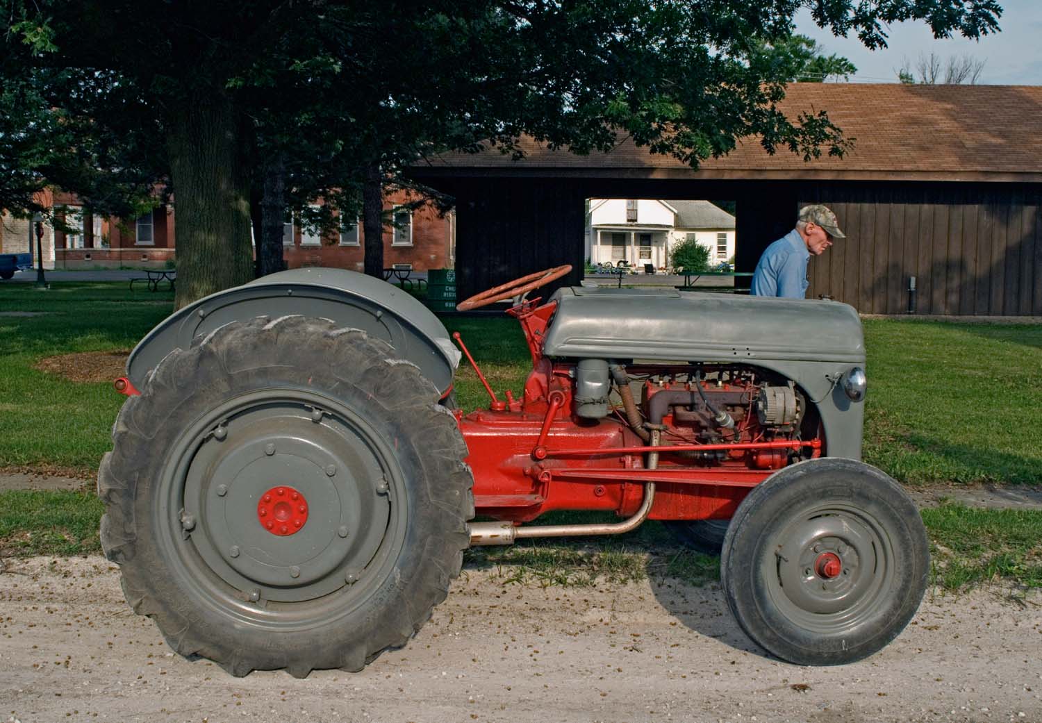  Ronald Moormann, a local farmer walking by an antique Ford tractor. Bowen, IL. July, 2007  