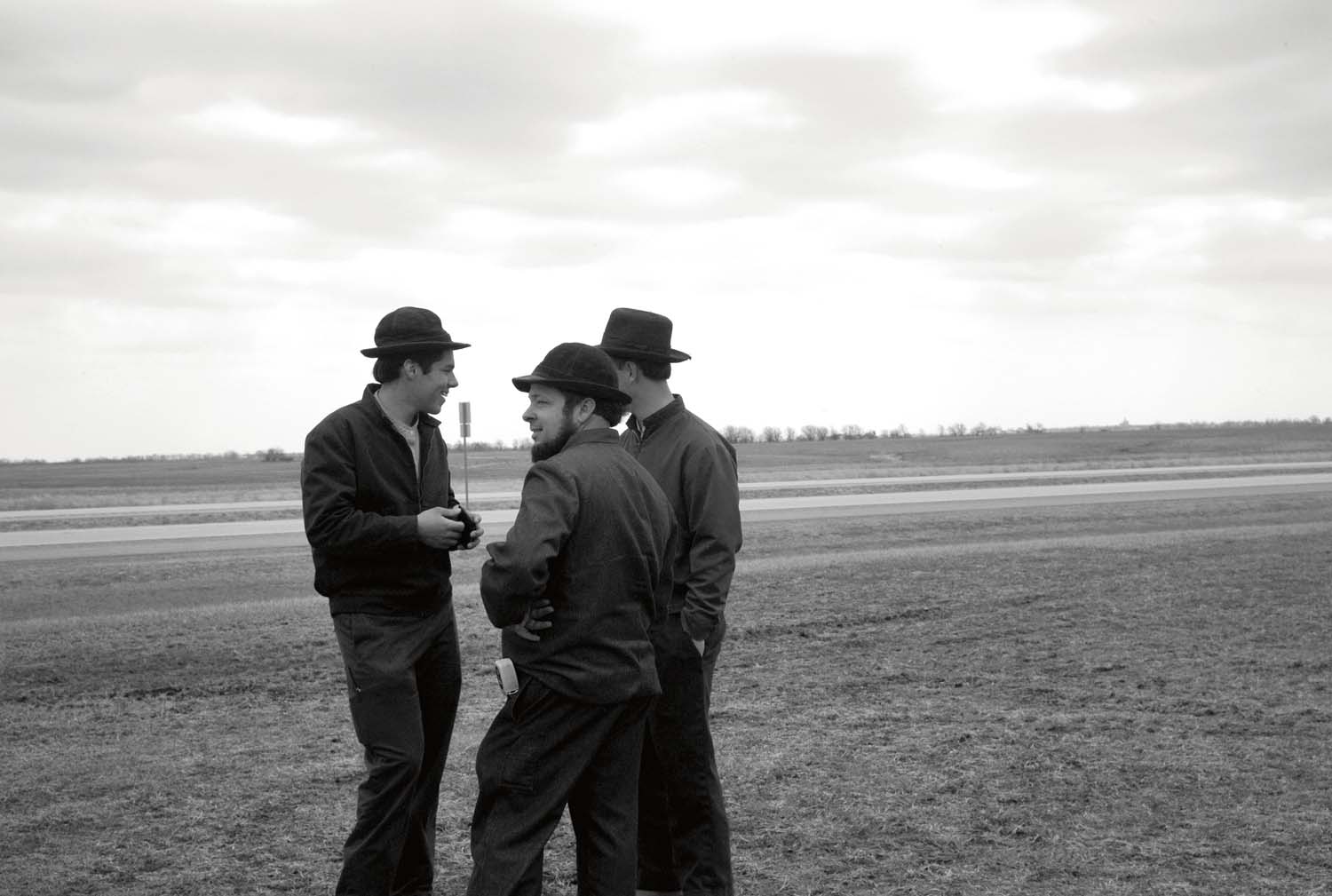  Three young Mennonite men standing together at an auction near Denver, IL. March, 2011 
