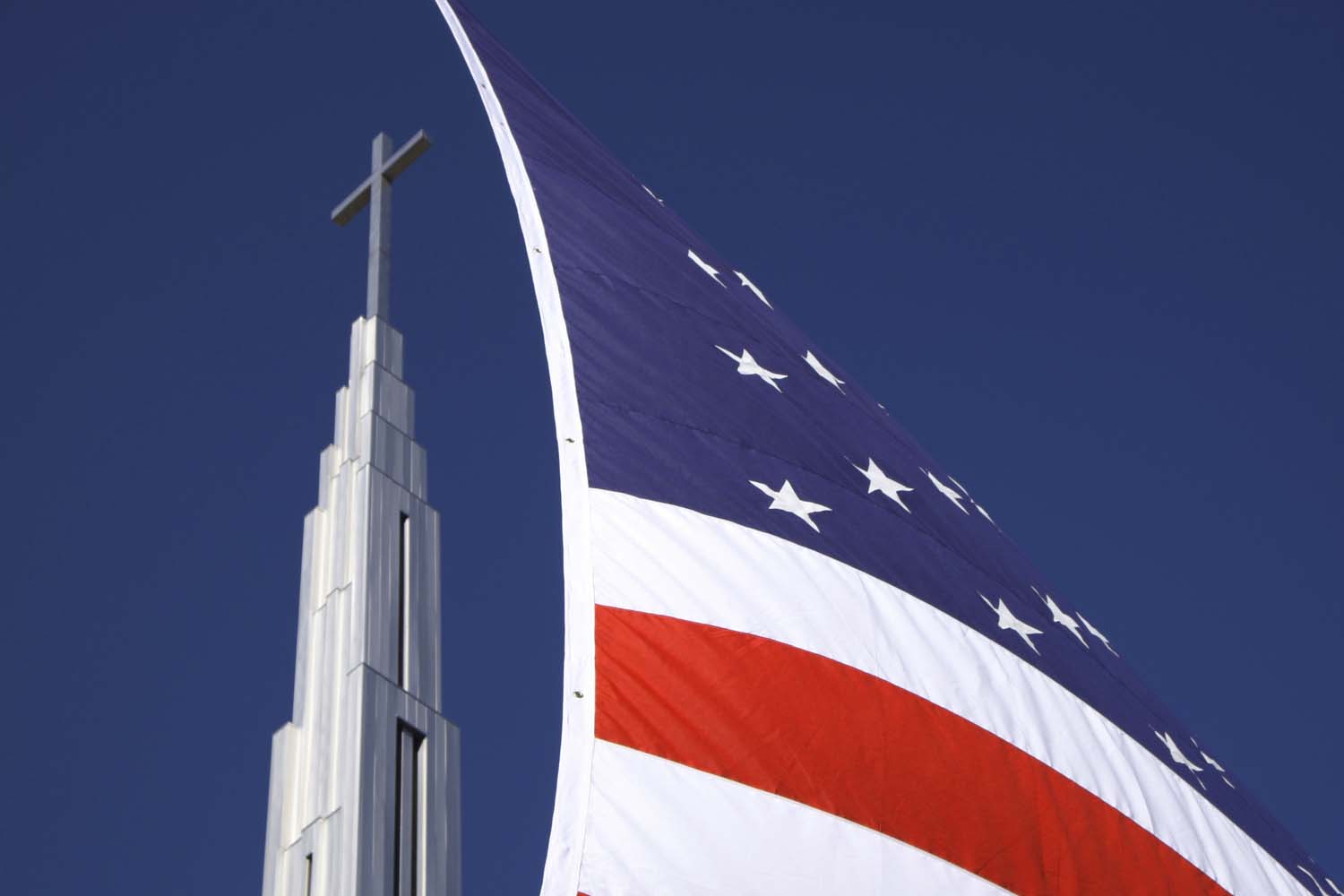  Church steeple and cross, with American flag on display at a Veterans Day parade. Quincy IL. November, 2015 