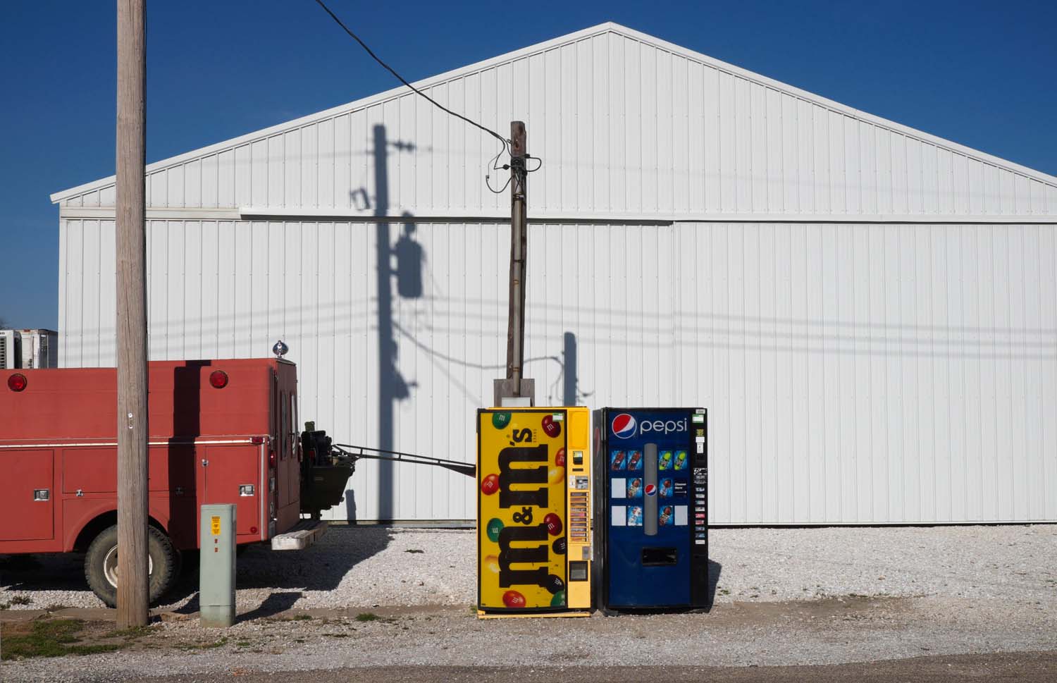  Two vending machines, red truck, and white building. Vending machines selling soda and candy are the only items for sale in this town. Summum, IL November, 2016 