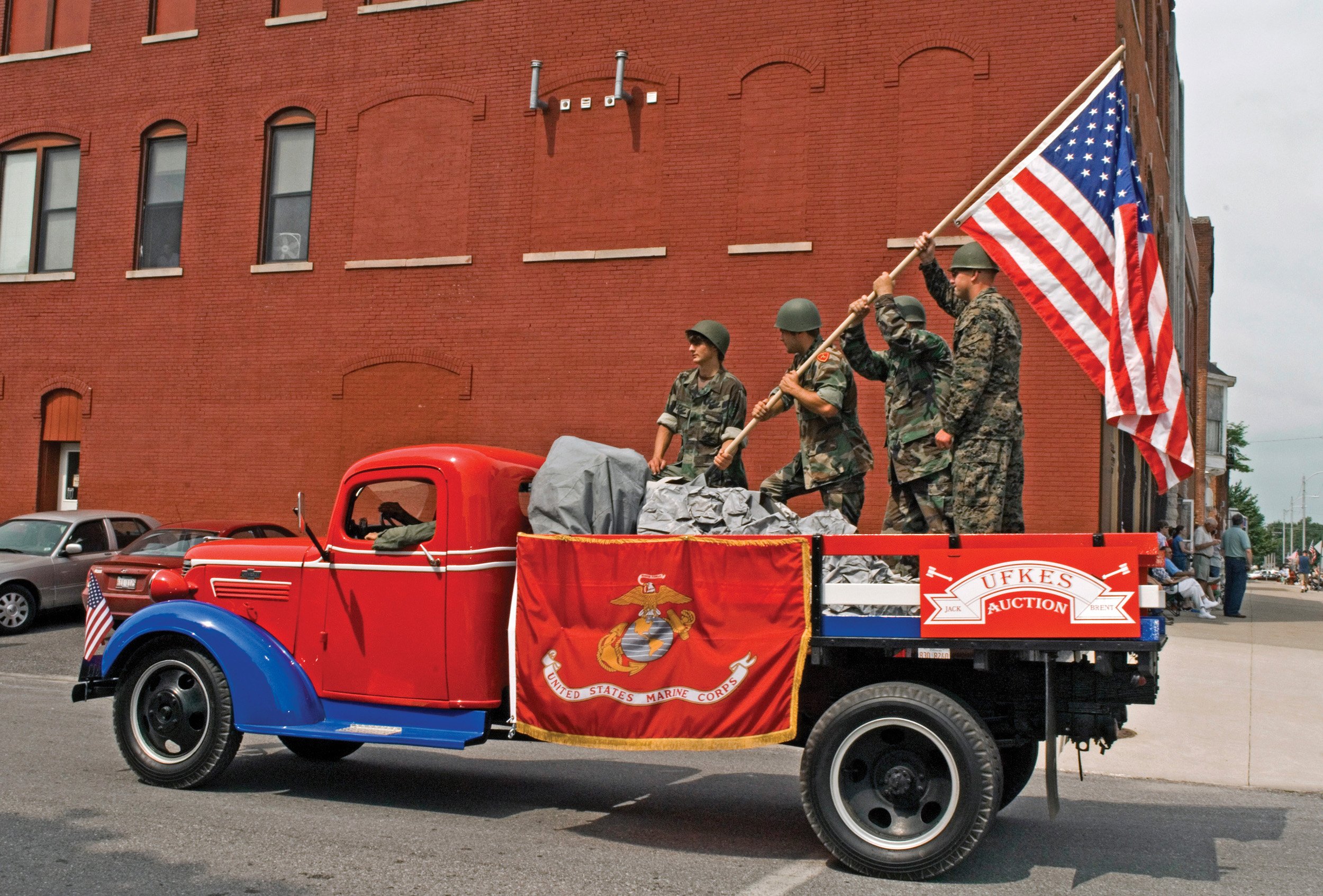  Four men standing in a red truck with an American flag. Fourth of July parade in Carthage, IL. July, 2007 