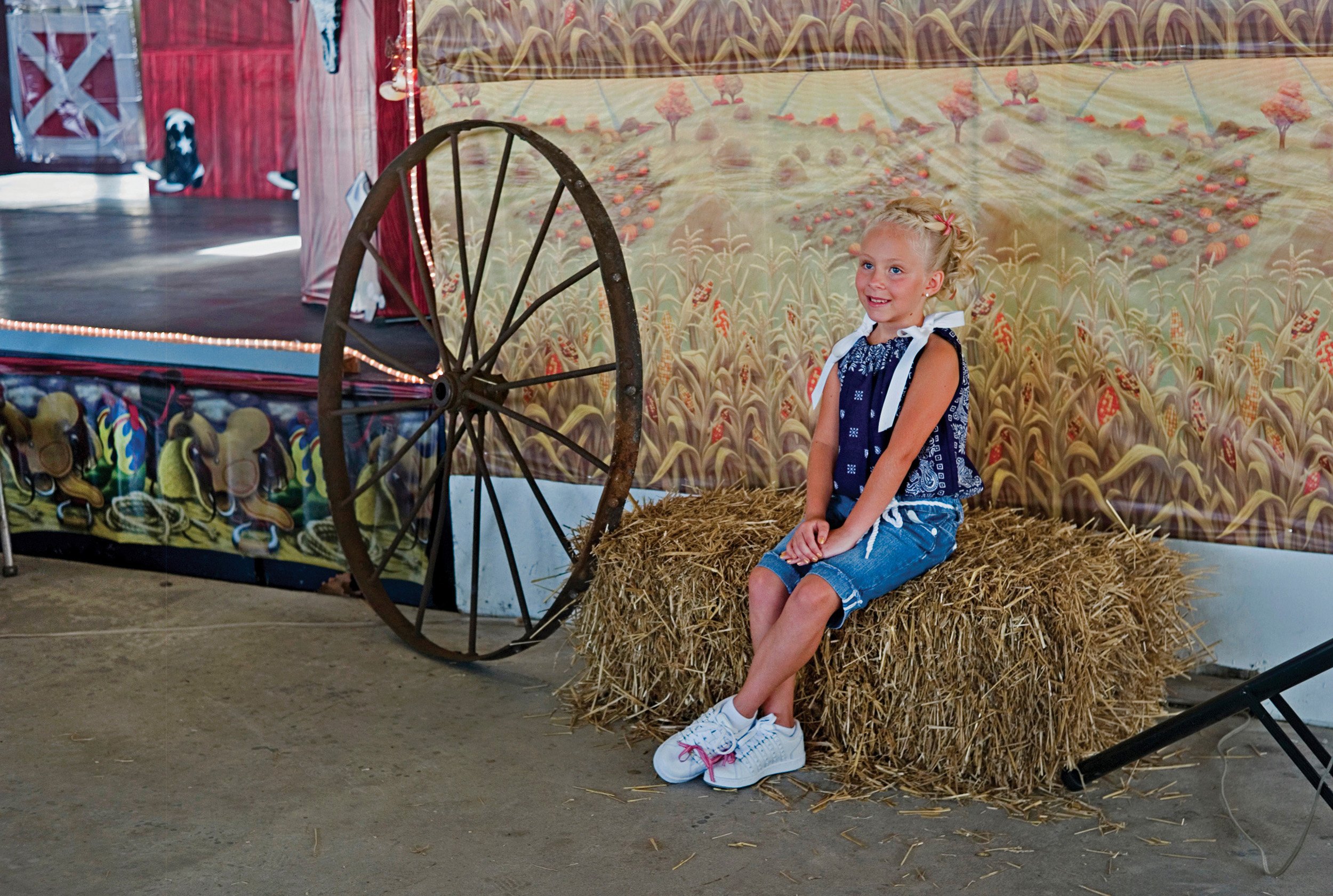  Beauty pageant contestant sitting on a bale of straw at the Hancock County Fair. Augusta, IL. July, 2010   